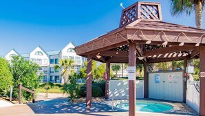 A covered outdoor area with a pool, wooden pergola, and a gated entrance. - Gulf Shores Plantation II by Southern Vacation Rentals (Gulf Shores)