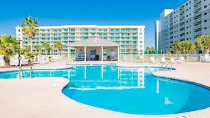 A hotel with a swimming pool, a covered seating area, and a multi-story building with balconies. - Gulf Shores Plantation II by Southern Vacation Rentals (Gulf Shores)