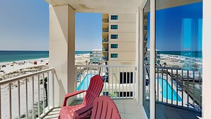 A balcony with a view of the beach and a pool area. - Island Towers by Southern Vacation Rentals (Gulf Shores)