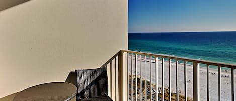 A balcony with a view of a beach and ocean.