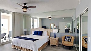 A hotel room with a large bed, two bedside tables, a chair, and a large mirror.