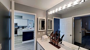 A modern bathroom with a large mirror, vanity, and a sink.