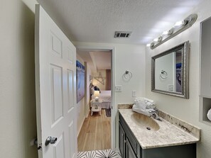 Une salle de bain d’hôtel avec un lavabo, un miroir et un porte-serviettes.