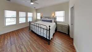 A bedroom with a bed, nightstand, and a ceiling fan. - Muskoka by Southern Vacation Rentals (Gulf Shores)