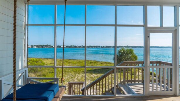 A room with a large window overlooking a beach and ocean. - Muskoka by Southern Vacation Rentals (Gulf Shores)