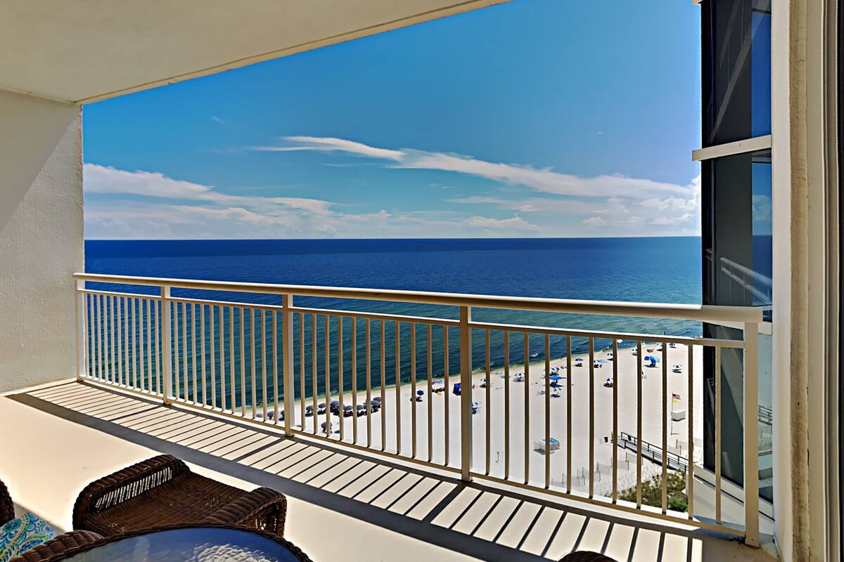 A balcony with a view of the ocean and beach.