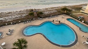 A pool area with a view of the beach and ocean.