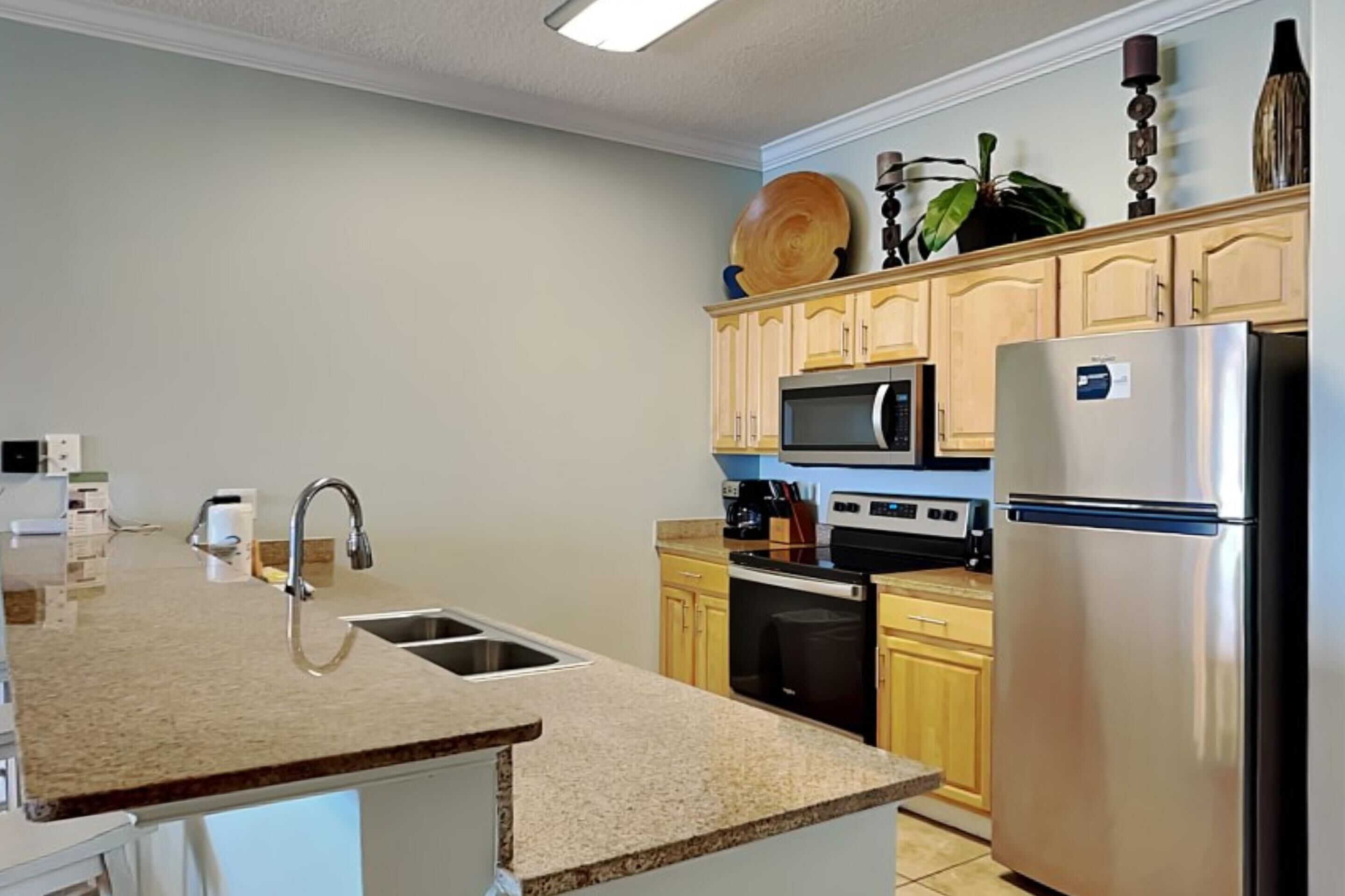 A modern kitchen with granite countertops, stainless steel appliances, and wooden cabinets.