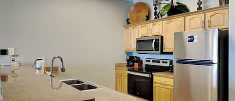 A modern kitchen with granite countertops, stainless steel appliances, and wooden cabinets.