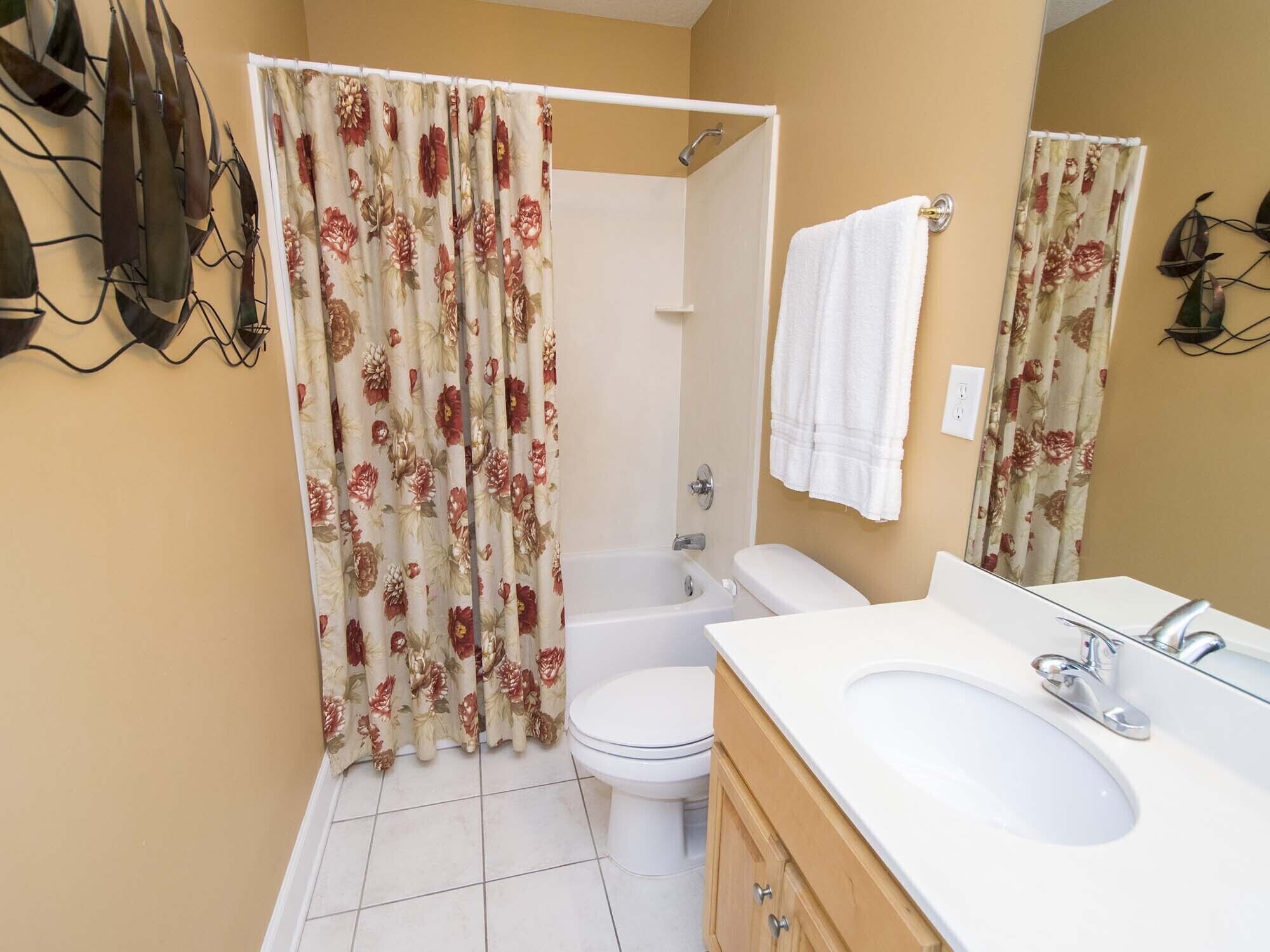 A bathroom with a shower, toilet, and sink.