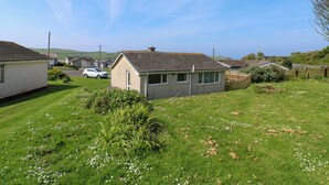 A residential area with houses, a grassy field, and a clear sky. - Jasper's Corner (Kingsbridge)