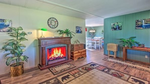 Ein Wohnzimmer mit Kamin, einem Essbereich und einem Flur mit Kunstwerken.