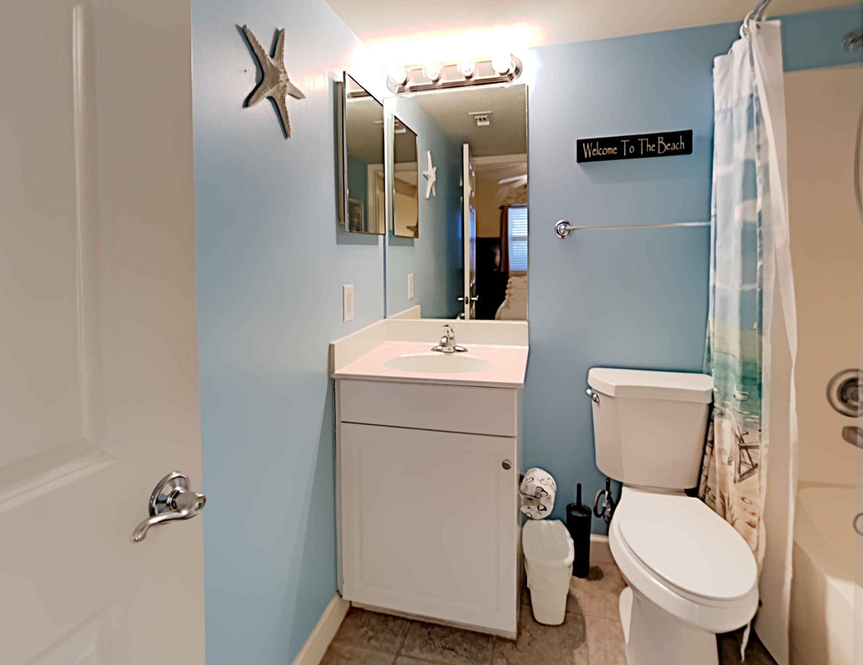 A bathroom with a sink, toilet, and a shower curtain.