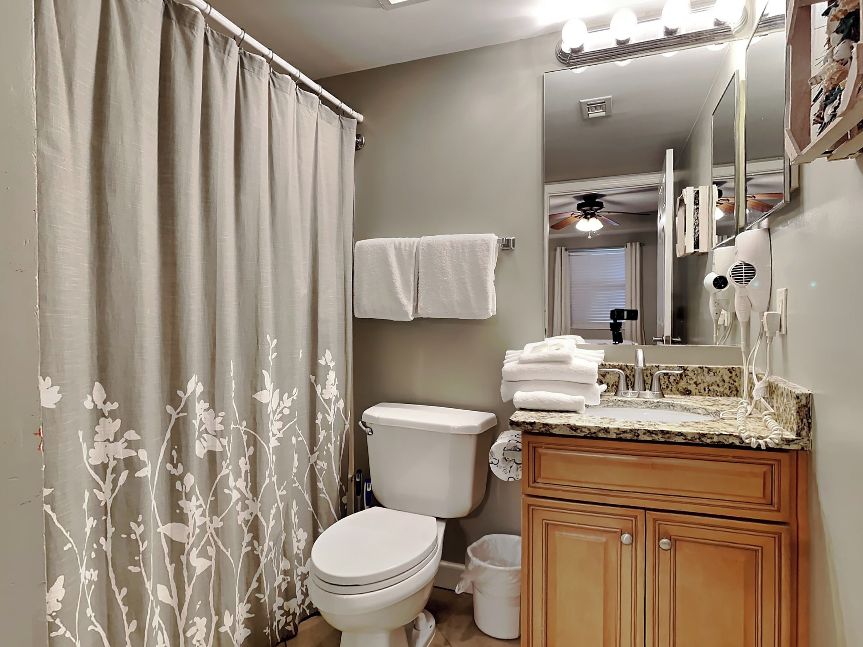 A bathroom with a toilet, sink, and shower curtain.