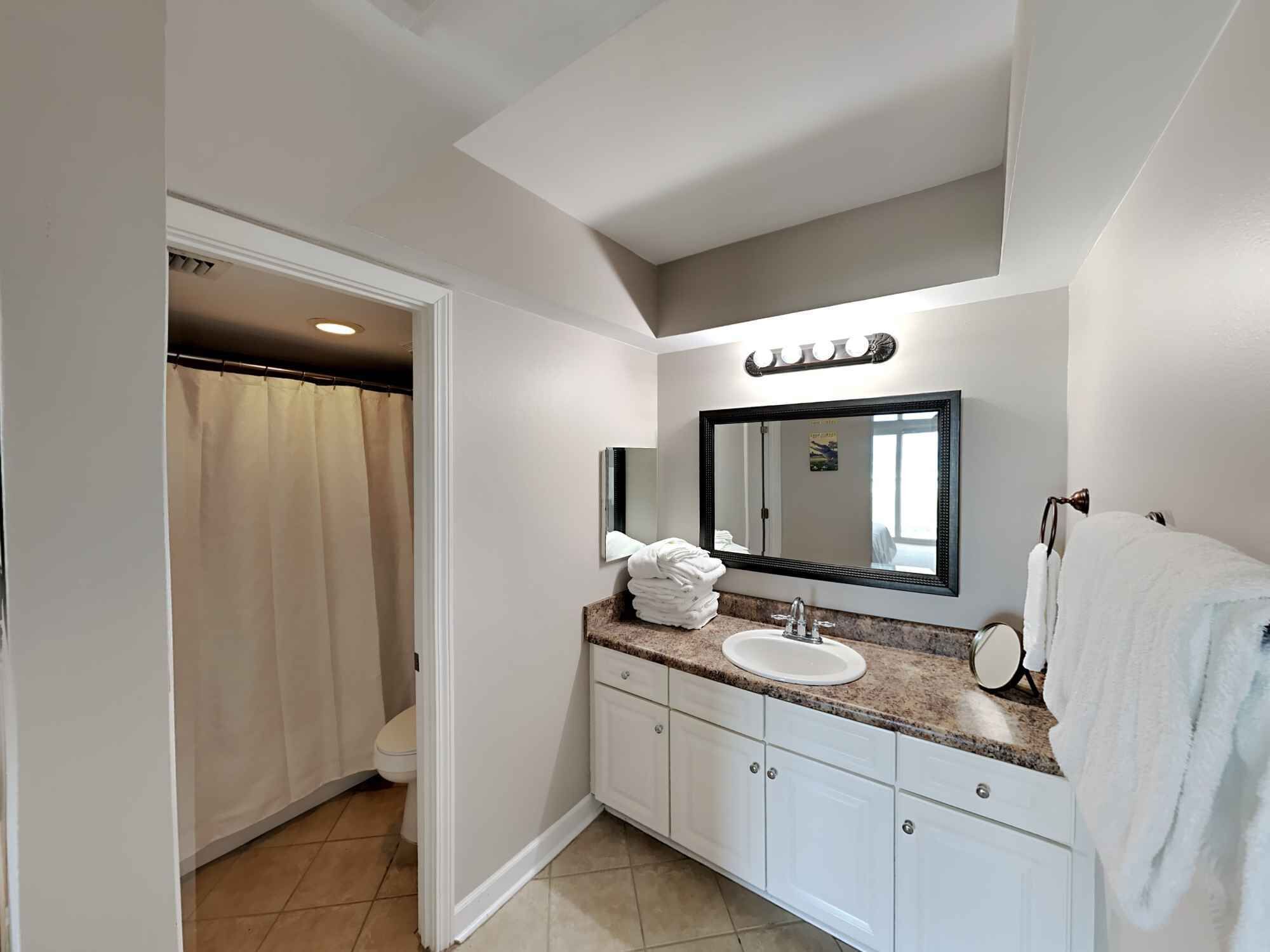 A modern bathroom with a vanity, sink, and mirror.