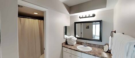 A modern bathroom with a vanity, sink, and mirror.