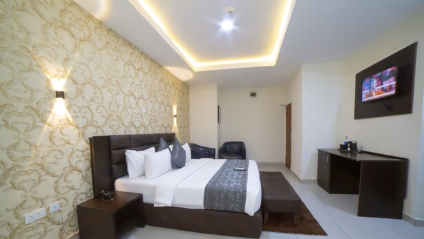A modern hotel room with a large bed, bedside tables, a desk, and a TV. - Empresa Hotel & Spa (Lekki)