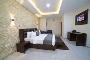 A modern hotel room with a large bed, bedside tables, a desk, and a TV. - Empresa Hotel & Spa (Lekki)