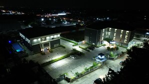A multi-story hotel with a parking lot, a swimming pool, and a landscaped garden area. - Empresa Hotel & Spa (Lekki)