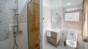 A bathroom with a shower, toilet, sink, and vanity. - Empresa Hotel & Spa (Lekki)
