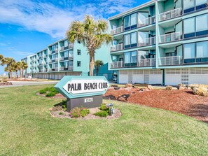 A multi-story hotel with balconies and a sign indicating it is the Palm Beach Club. - Palm Beach Club by Southern Vacation Rentals (Pensacola Beach)