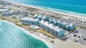 A resort with multiple buildings, a swimming pool, and a beach area. - Palm Beach Club by Southern Vacation Rentals (Pensacola Beach)