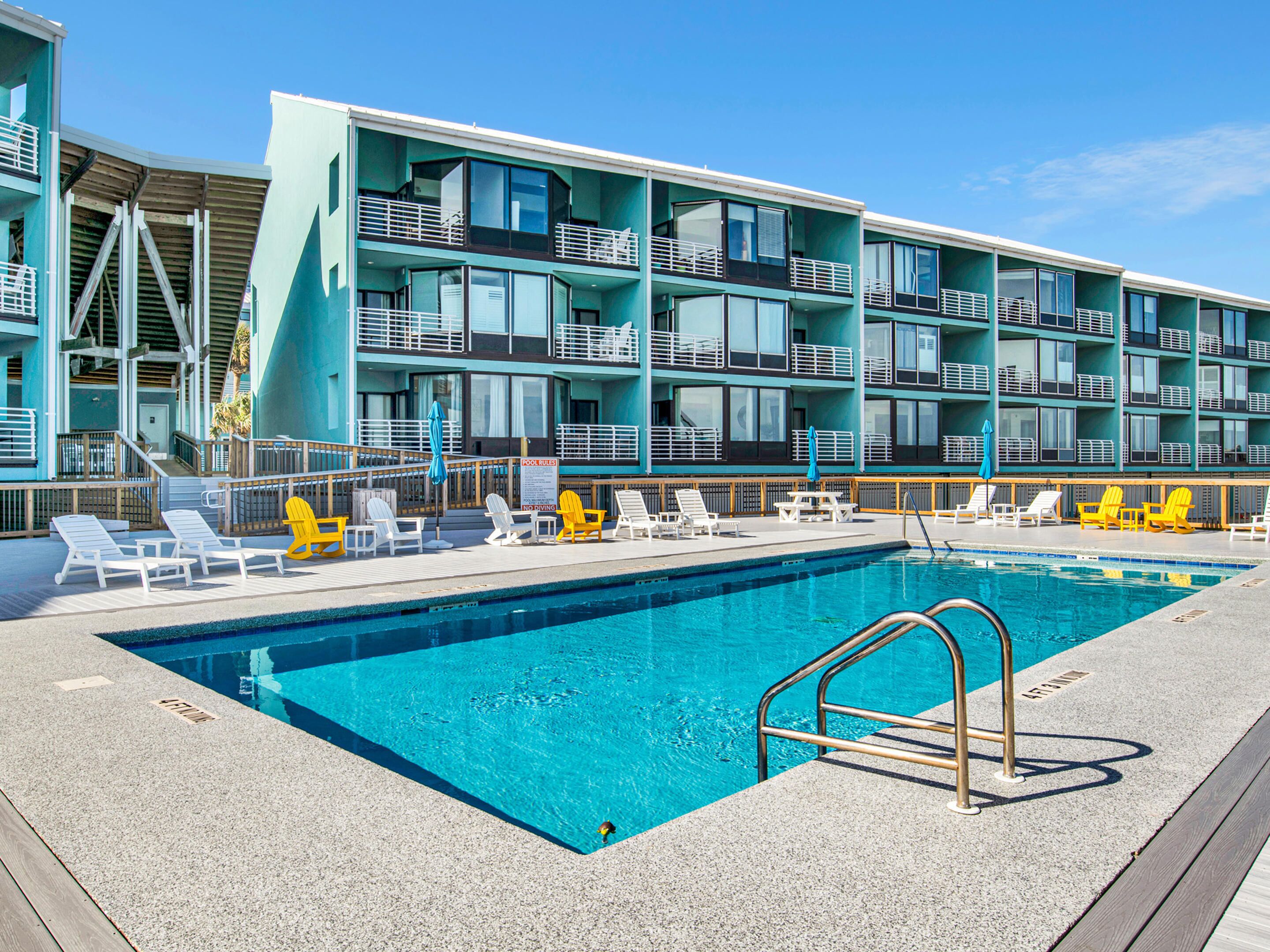 A swimming pool with lounge chairs and a poolside area.