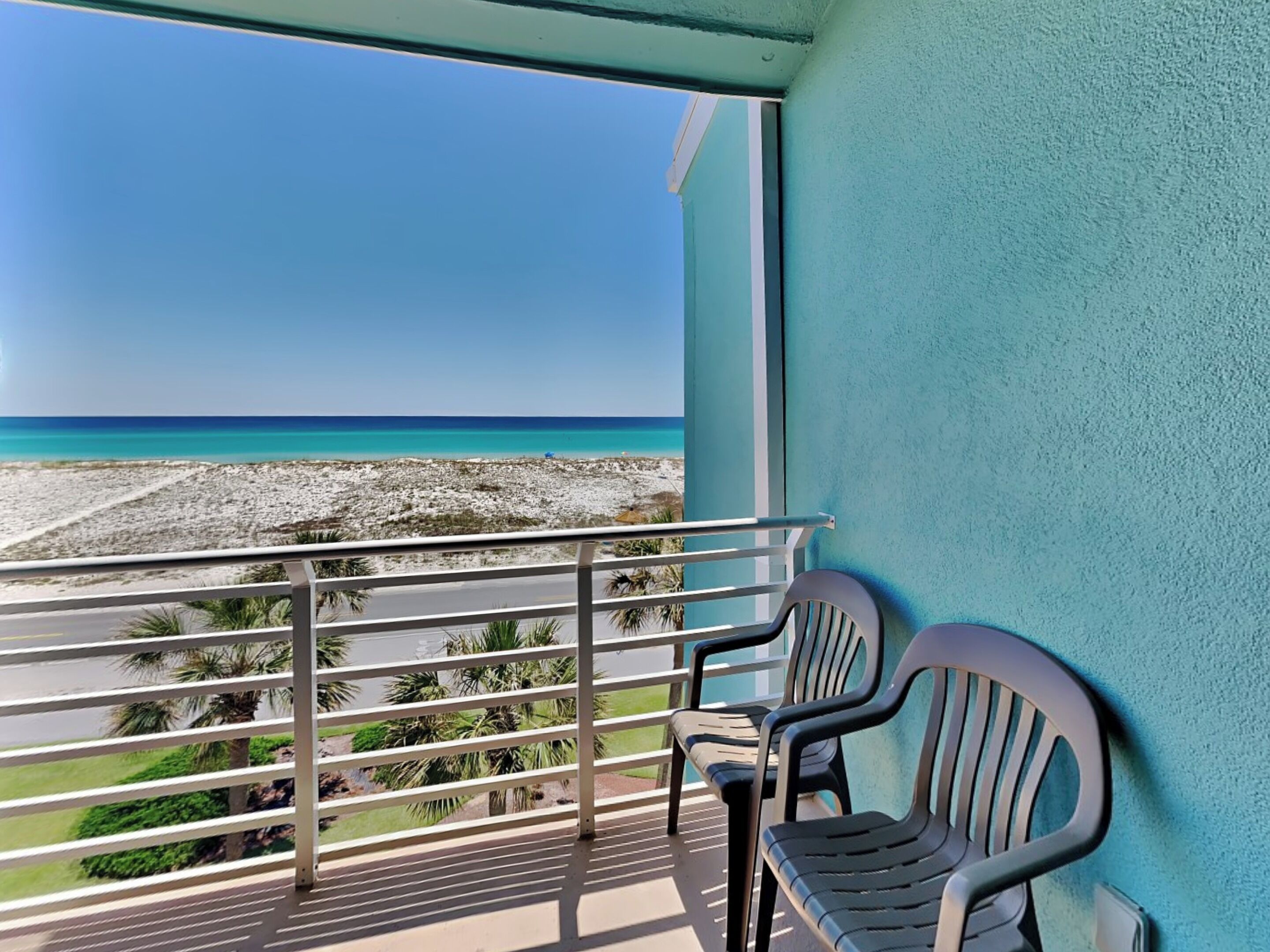 A balcony with a view of a beach and ocean.