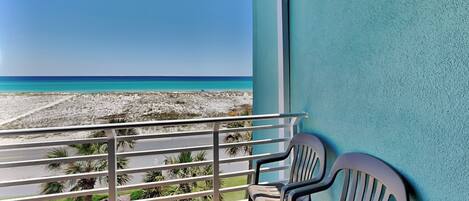 A balcony with a view of a beach and ocean.
