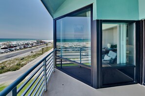 A balcony with a view of the beach and parked cars. - Palm Beach Club by Southern Vacation Rentals (Pensacola Beach)