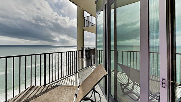 A balcony with a view of the sea, a table, and chairs. - The Oasis at Orange Beach by Southern Vacation Rentals (Orange Beach)