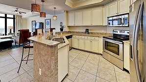 A modern kitchen with a central island, stainless steel appliances, and light-colored cabinetry. - The Oasis at Orange Beach by Southern Vacation Rentals (Orange Beach)