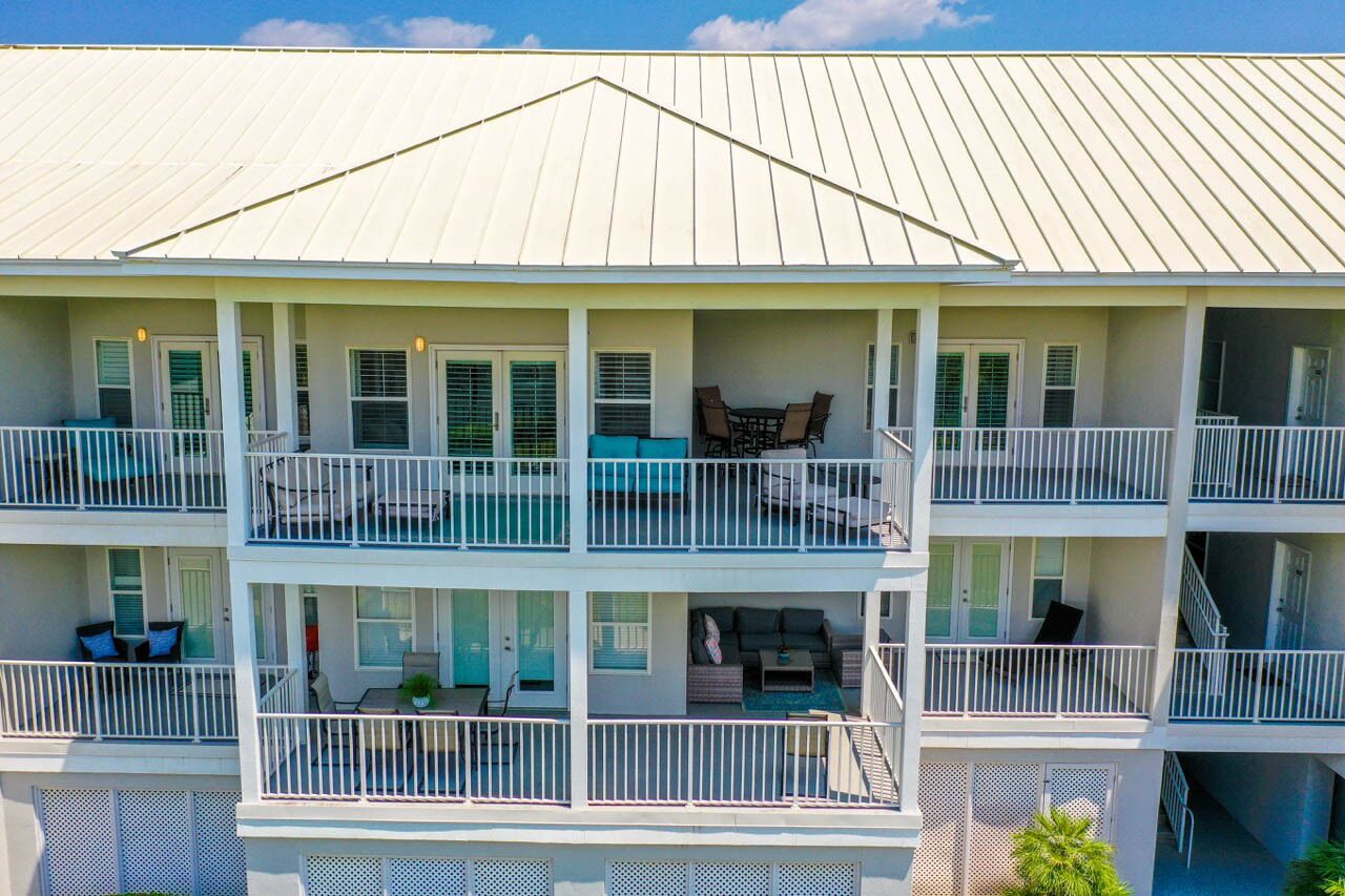 A multi-story building with balconies, outdoor seating, and a covered patio area.