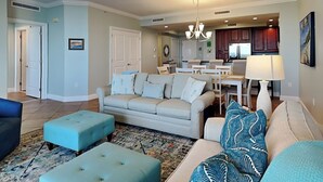 A spacious living room with a sofa, ottomans, and a dining area with a table and chairs. - San Anton by Southern Vacation Rentals (Pensacola)
