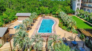 A resort with a large pool surrounded by palm trees and a tennis court. - Redfish Village by Southern Vacation Rentals (Santa Rosa Beach)
