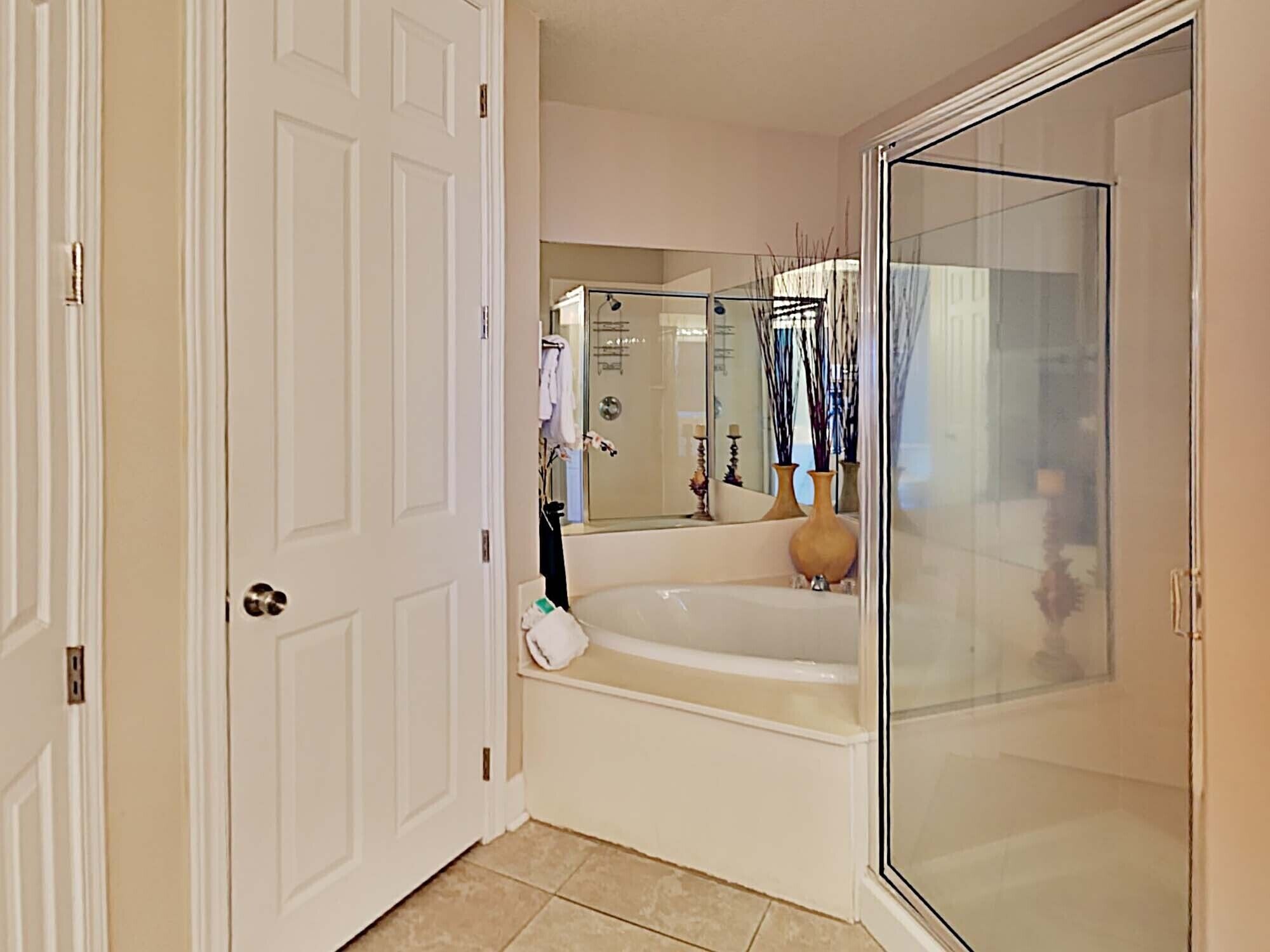 A bathroom with a glass-enclosed shower, a bathtub, and a mirror.