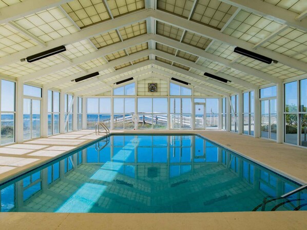An indoor swimming pool with large windows and a high ceiling.
