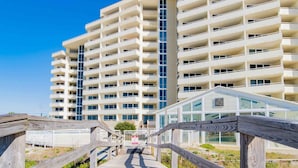 Un immeuble de grande hauteur doté de nombreux balcons et d’une façade en verre.