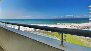 Un balcon avec vue sur une plage et l’océan.