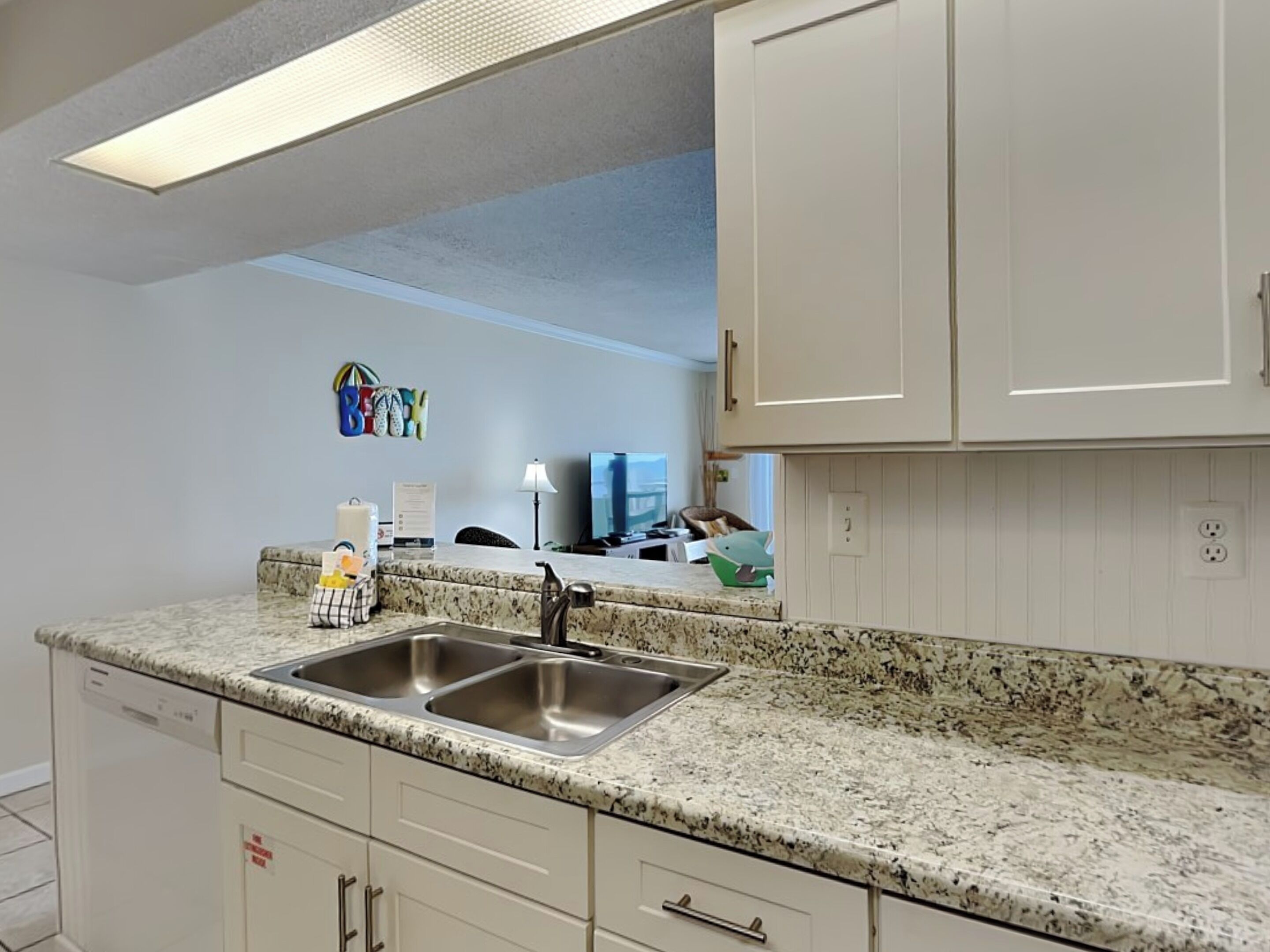 A kitchen with white cabinets, a granite countertop, and stainless steel appliances.