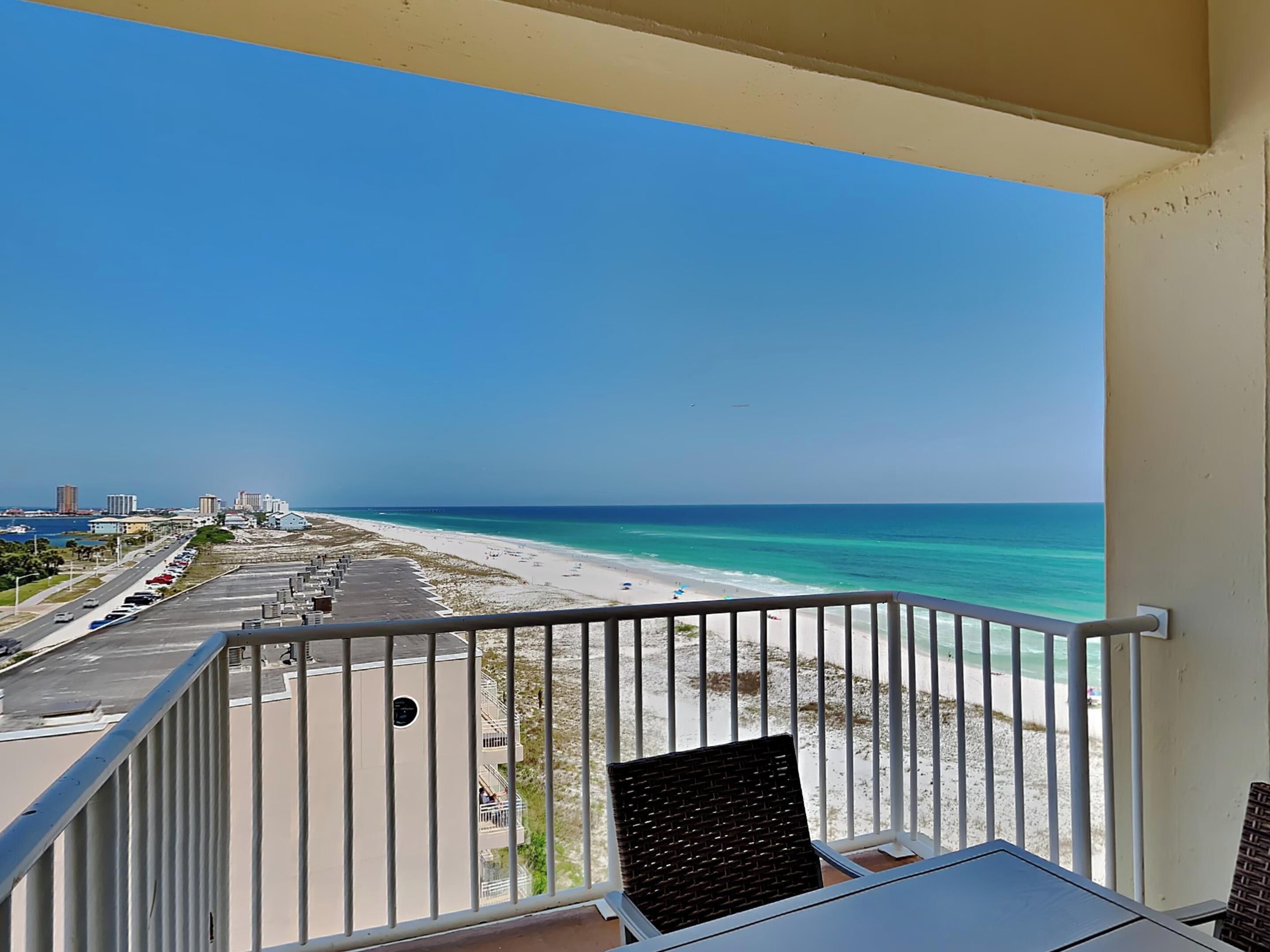 Ein Balkon mit Blick auf einen Strand und einen Parkplatz.