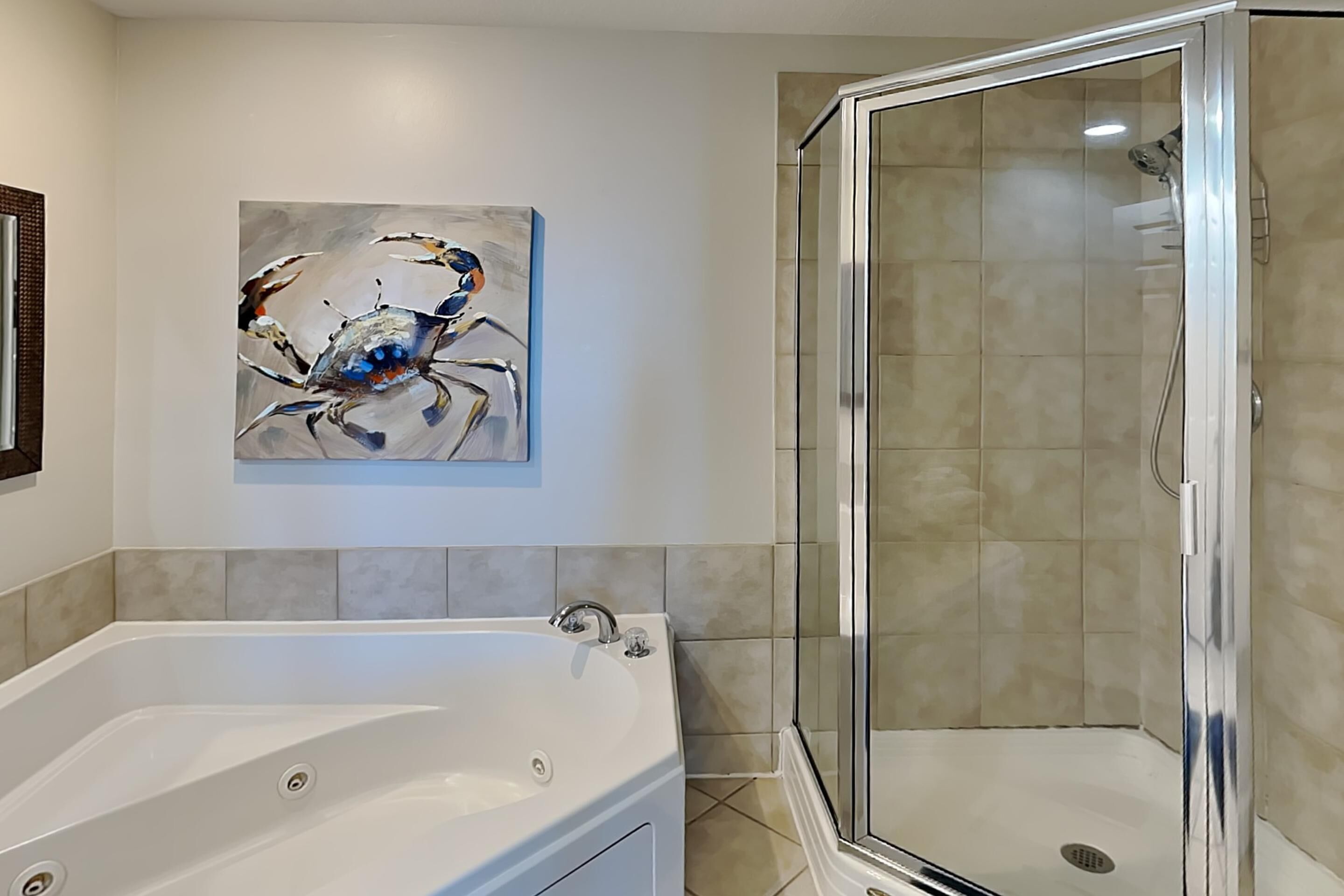 Un baño con bañera, cabina de ducha de vidrio y un cuadro en la pared.