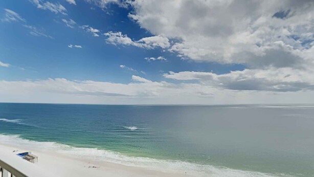 A beach view from a balcony with a railing, ocean, and clear sky. - San Carlos by Southern Vacation Rentals (Gulf Shores)