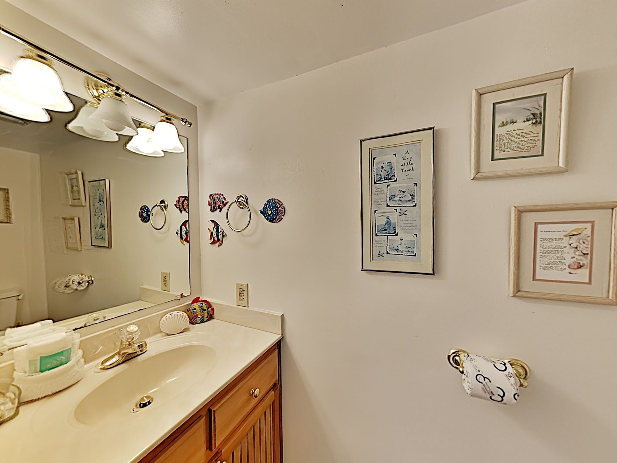 A bathroom with a sink, mirror, and wall-mounted towel rings.