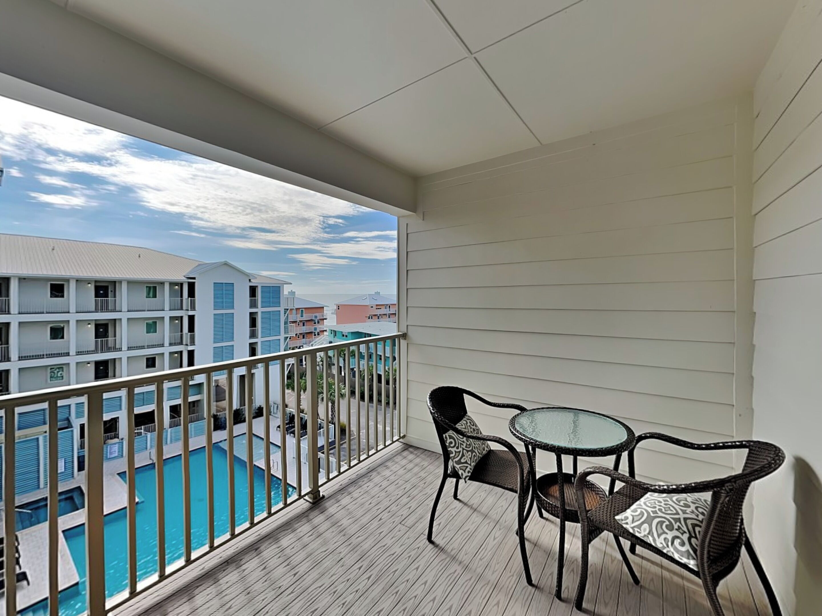 Un balcon donnant sur une piscine et les bâtiments adjacents.