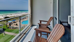 A balcony with a view of a beach and pool area. - Sterling Sands by Southern Vacation Rentals (Destin)
