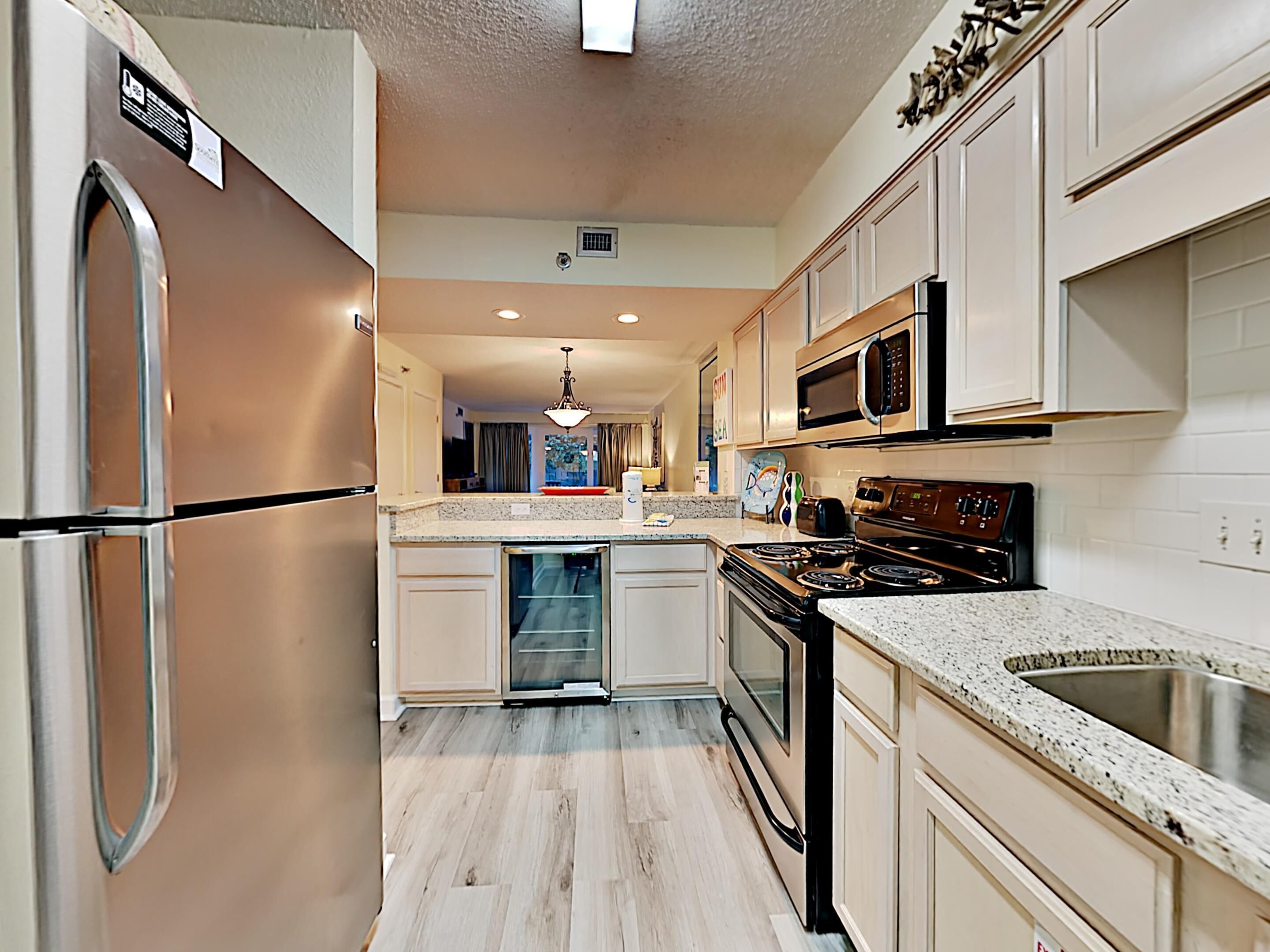 A modern kitchen with stainless steel appliances, a granite countertop, and a central island.