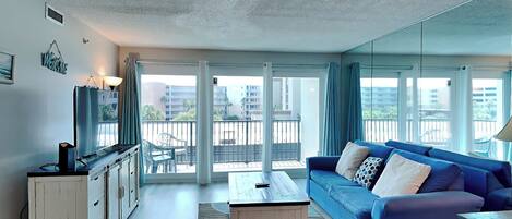 Een moderne woonkamer met een blauwe bank, een witte kast en een salontafel.