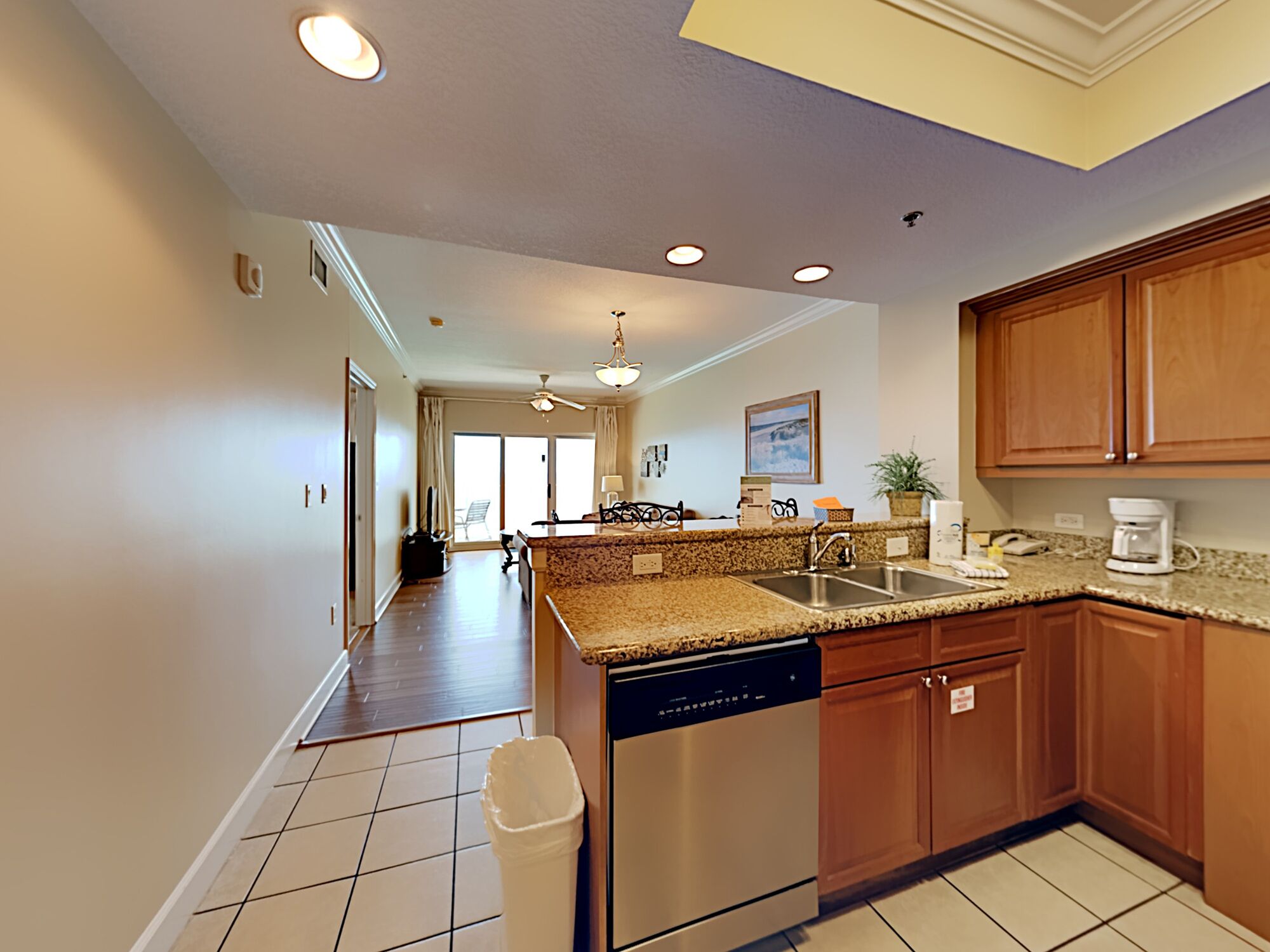 A modern kitchen with granite countertops, stainless steel appliances, and wooden cabinets.