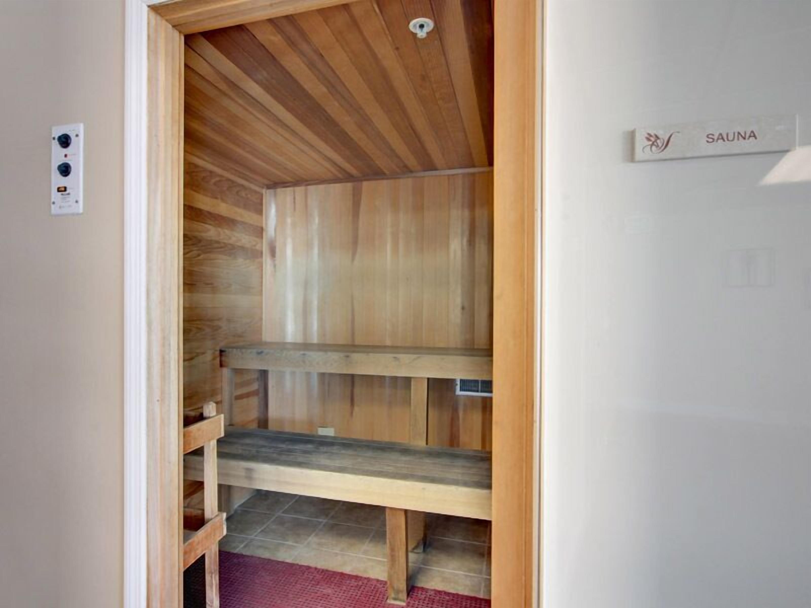 A sauna room with wooden walls and a bench.